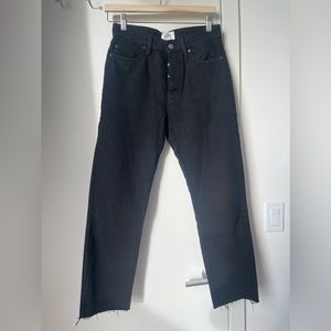 Black straight leg jeans with raw hem.